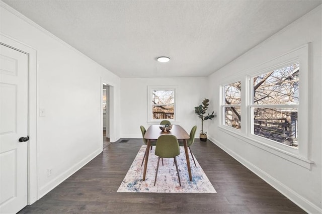 dining room featuring baseboards, dark wood-style flooring, and a textured ceiling