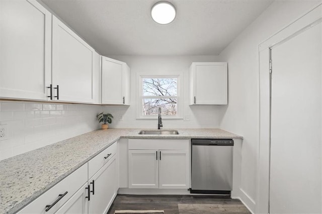 kitchen with dark wood finished floors, dishwasher, decorative backsplash, white cabinets, and a sink