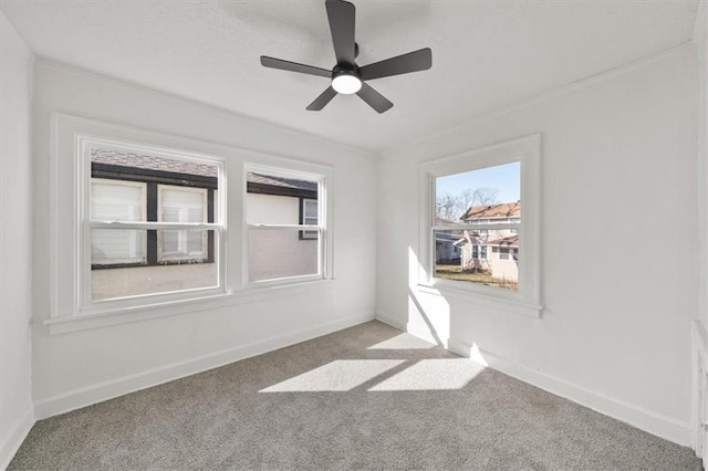 carpeted empty room featuring baseboards and ceiling fan