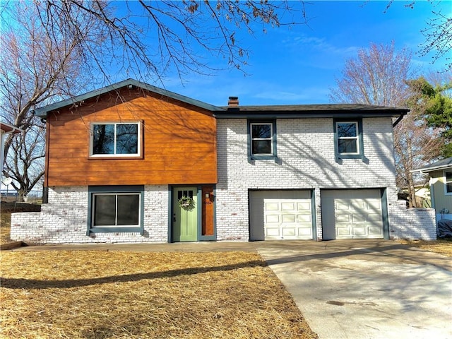 view of front of house with brick siding, a garage, and driveway