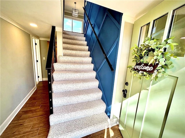 stairs with recessed lighting, wood finished floors, baseboards, and ornamental molding