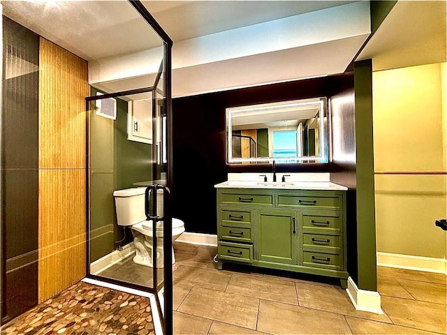 bathroom featuring baseboards, toilet, a stall shower, and vanity