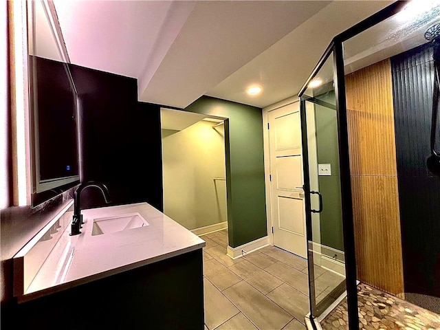 full bathroom with baseboards, vanity, and a shower stall