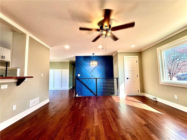 unfurnished living room featuring ceiling fan, visible vents, baseboards, and dark wood finished floors