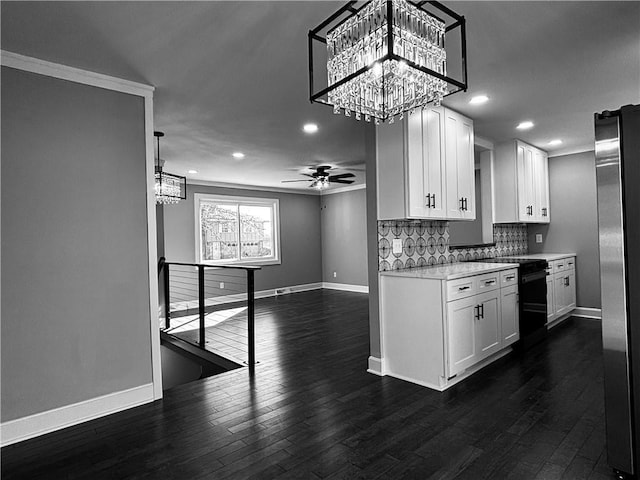 kitchen with dark wood finished floors, ceiling fan with notable chandelier, tasteful backsplash, and light countertops