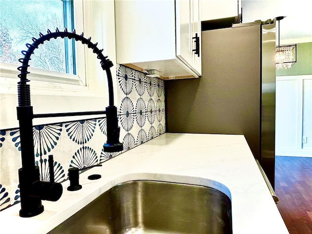 interior details featuring white cabinetry, light countertops, dark wood-style floors, and a sink