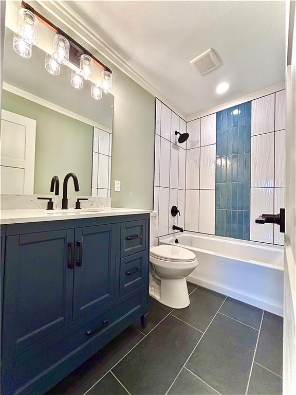 bathroom featuring tile patterned floors, toilet, crown molding, tub / shower combination, and vanity