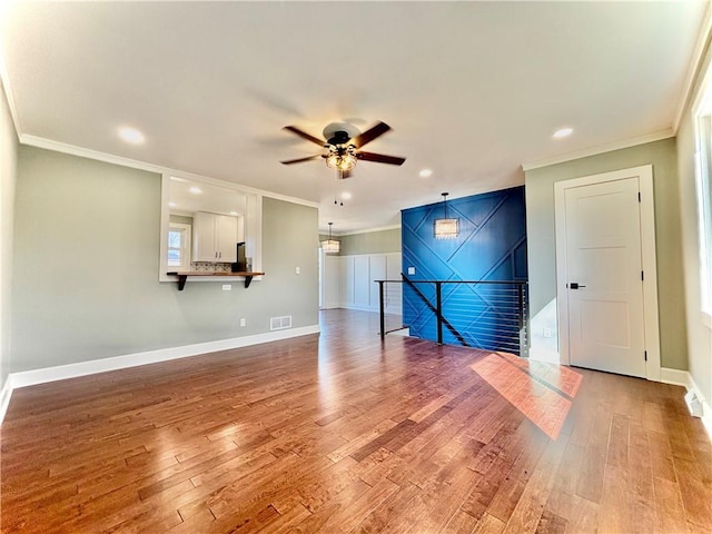 empty room featuring baseboards, ceiling fan, ornamental molding, recessed lighting, and light wood-style flooring