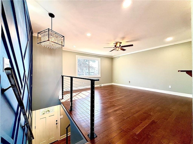 interior space featuring dark wood-type flooring, crown molding, and baseboards