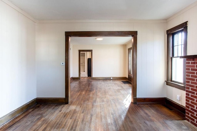 spare room with hardwood / wood-style flooring and baseboards