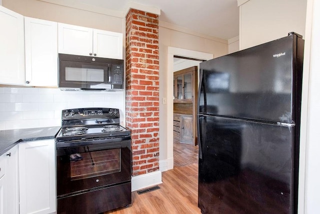 kitchen featuring dark countertops, visible vents, light wood finished floors, white cabinets, and black appliances