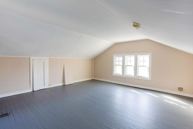 additional living space with vaulted ceiling and dark wood-style flooring