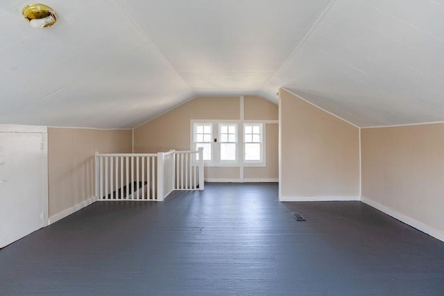 bonus room with visible vents, baseboards, lofted ceiling, and dark wood-style flooring