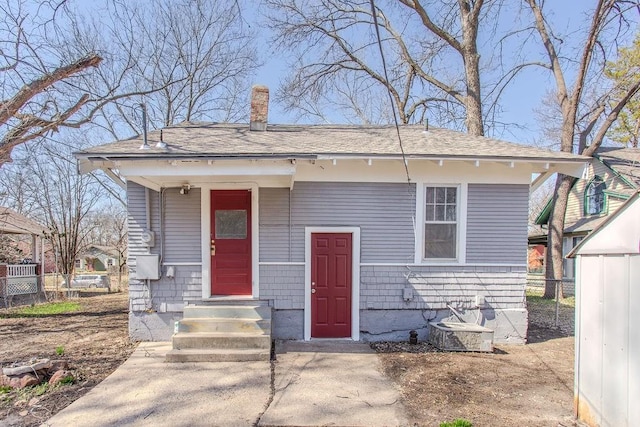 view of front facade featuring a chimney and fence