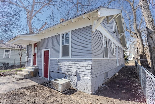 exterior space featuring central AC unit and fence