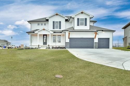 view of front of property with concrete driveway, a front lawn, and an attached garage