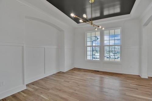 unfurnished dining area featuring a decorative wall and wood finished floors