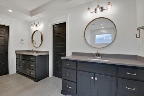 bathroom with tile patterned floors, two vanities, a sink, and recessed lighting