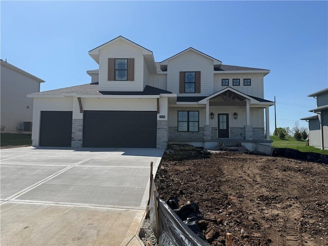 view of front facade with concrete driveway, a porch, stone siding, and board and batten siding