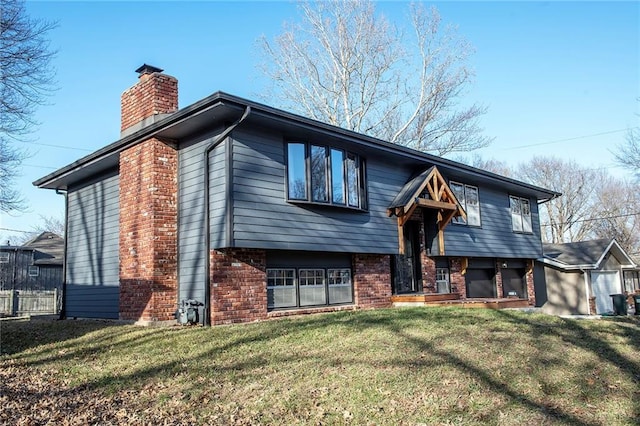 bi-level home featuring a front yard, brick siding, and a chimney