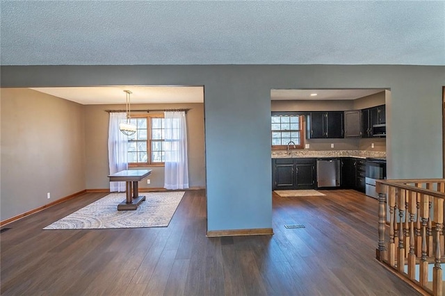 kitchen with dark wood finished floors, a healthy amount of sunlight, stainless steel appliances, and light countertops