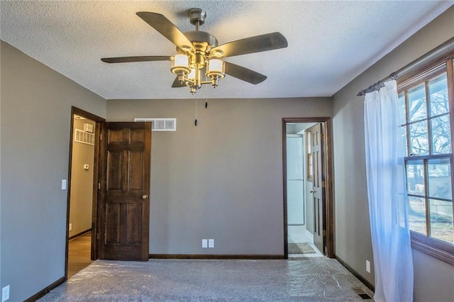 unfurnished bedroom featuring baseboards, visible vents, and a textured ceiling