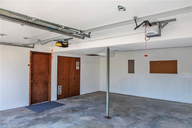 garage featuring electric panel, visible vents, and a garage door opener