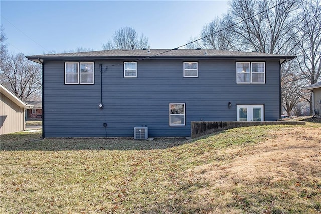 back of house featuring central AC unit and a lawn