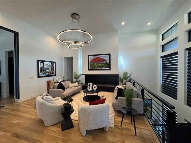 living room with a chandelier, recessed lighting, baseboards, and wood finished floors