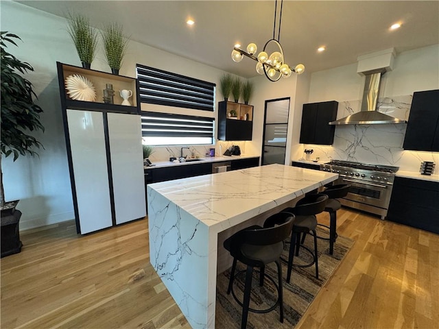 kitchen featuring range hood, a kitchen island, stainless steel appliances, modern cabinets, and dark cabinets