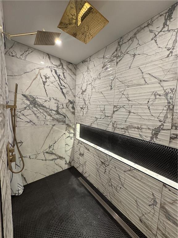 bathroom with a marble finish shower