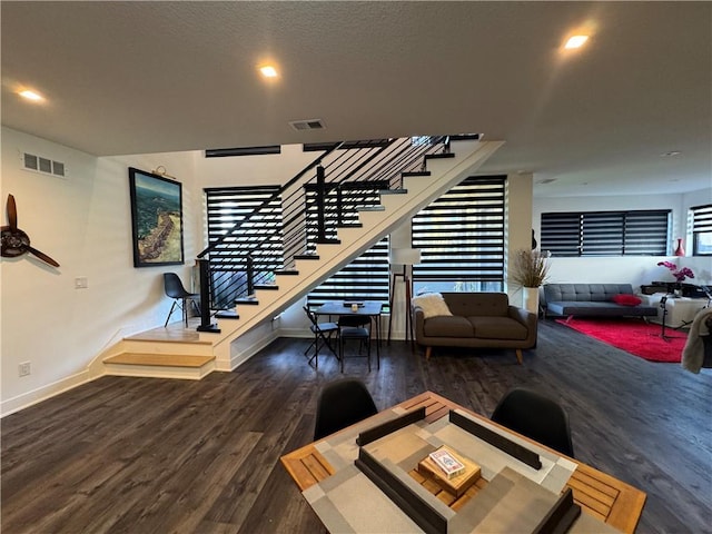 interior space with stairs, wood finished floors, visible vents, and baseboards