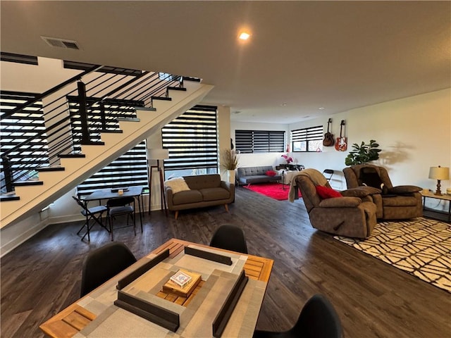 living area featuring stairs, wood finished floors, visible vents, and baseboards