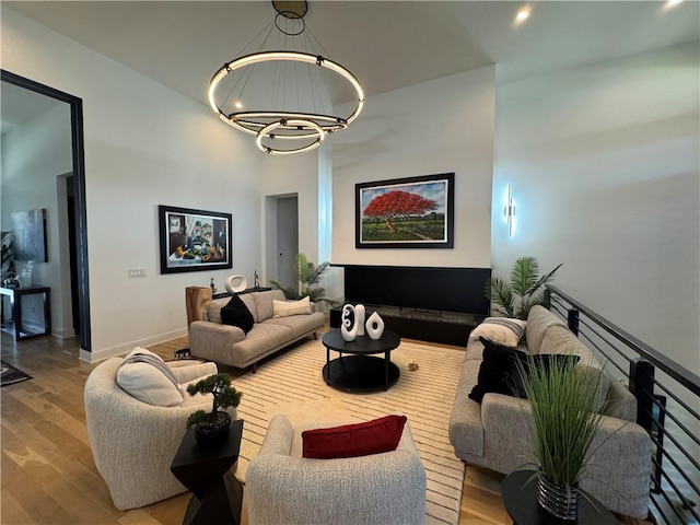 living area featuring baseboards, an inviting chandelier, and wood finished floors