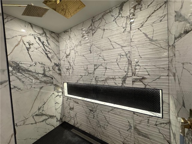 interior details featuring a marble finish shower