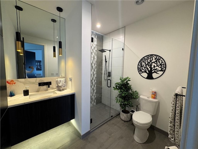 bathroom featuring baseboards, toilet, a stall shower, and vanity