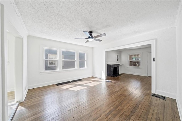 unfurnished living room with visible vents, baseboards, a ceiling fan, and hardwood / wood-style flooring