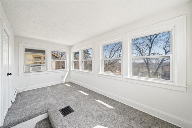 unfurnished sunroom with visible vents, a healthy amount of sunlight, and cooling unit