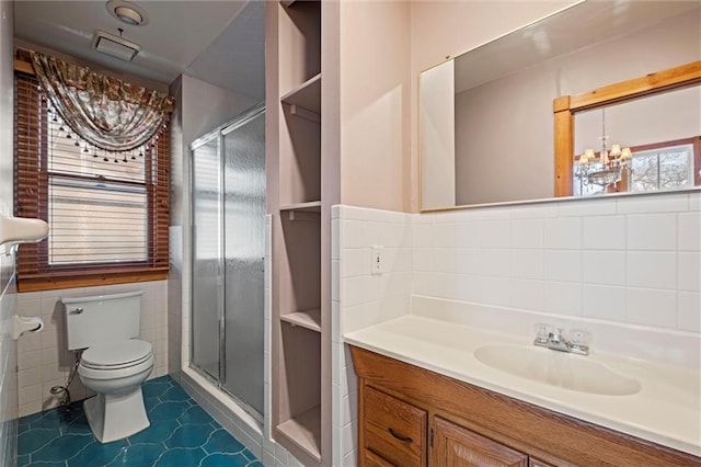 full bath with a chandelier, toilet, a stall shower, and tile walls