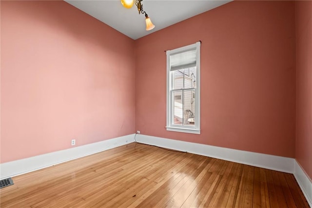 spare room with visible vents, baseboards, and light wood-style floors