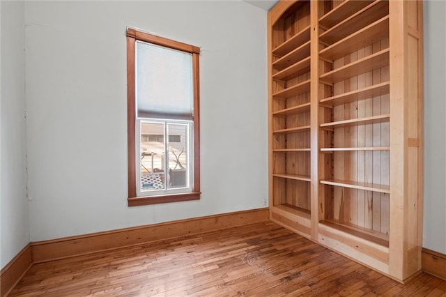 empty room with baseboards and wood-type flooring