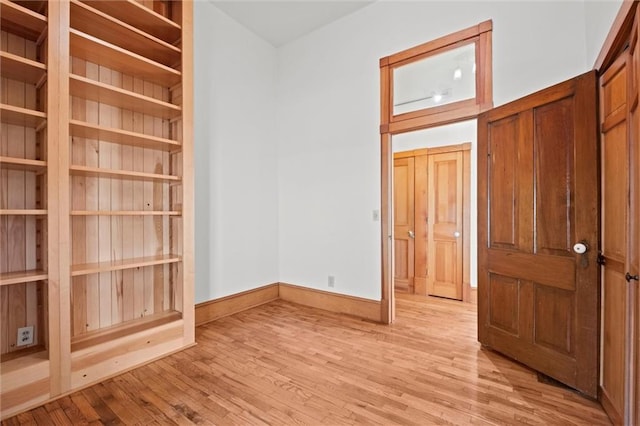 empty room with light wood-style flooring and baseboards