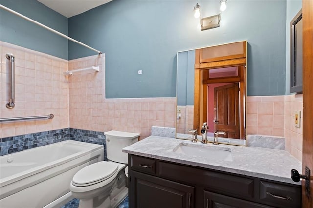 bathroom with a wainscoted wall, toilet, tile walls, washtub / shower combination, and vanity