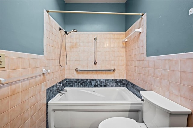 bathroom featuring tile walls, toilet, and shower / tub combination