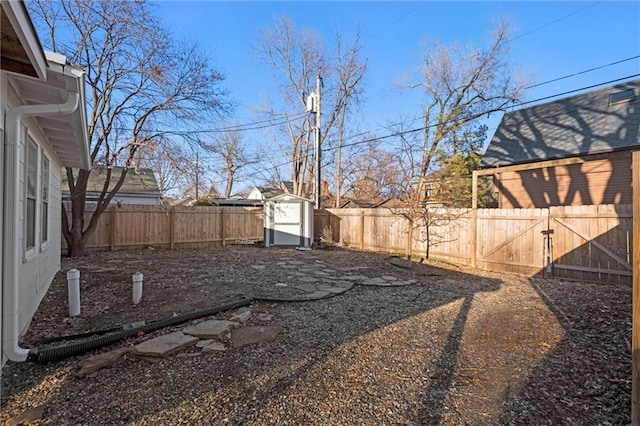 view of yard featuring a storage unit, a fenced backyard, and an outdoor structure