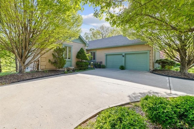 view of front of property with concrete driveway, stucco siding, and a garage