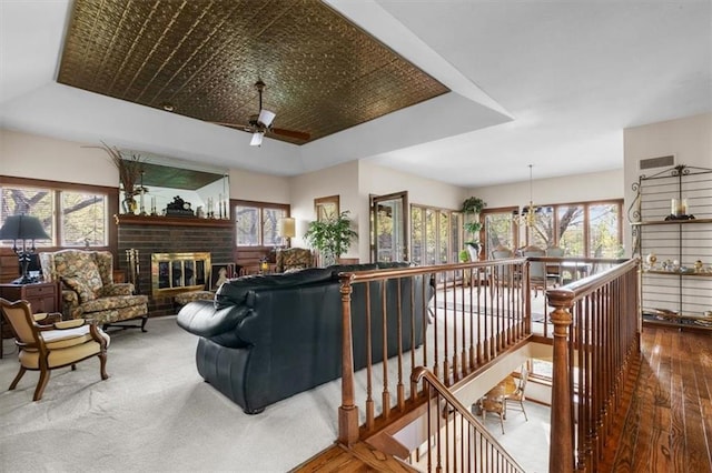 living room featuring plenty of natural light, a ceiling fan, and a tray ceiling
