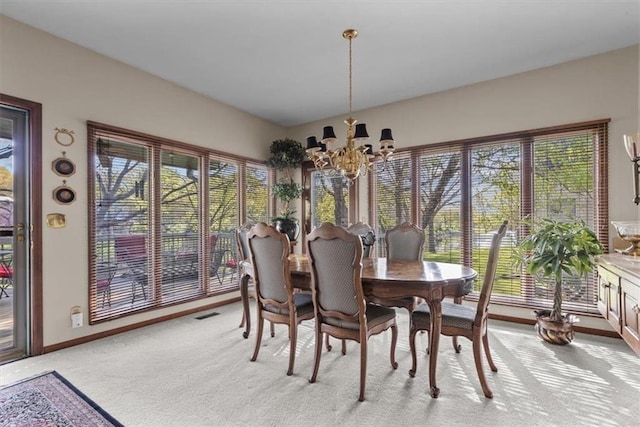 dining space featuring a healthy amount of sunlight, baseboards, light carpet, and a chandelier