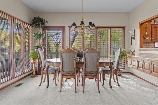 dining space with baseboards, a chandelier, light carpet, and visible vents