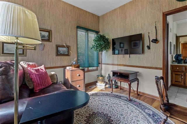 interior space featuring baseboards, wood finished floors, and wallpapered walls